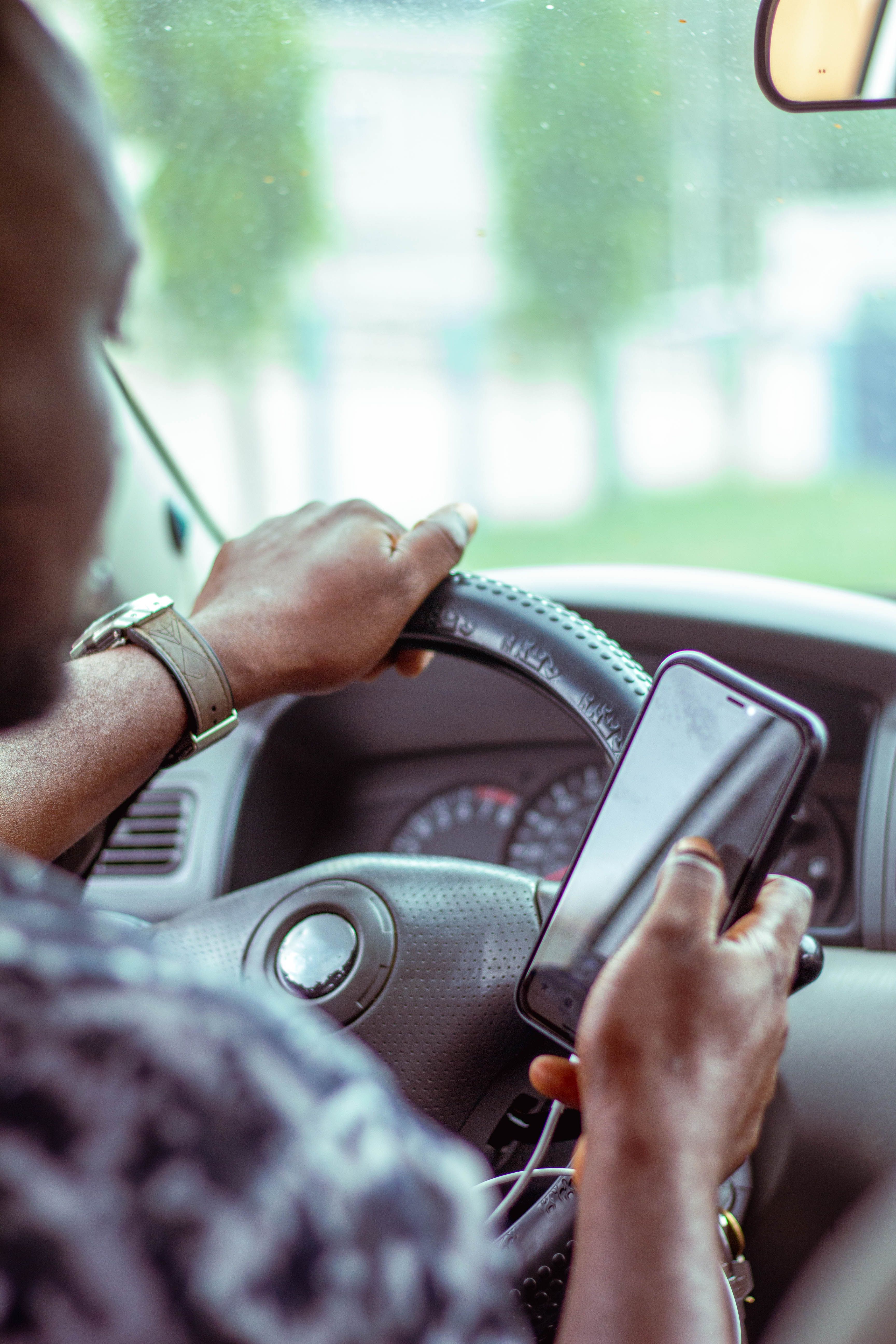 Motorista de aplicativo registrando informações no celular imediatamente após encerramento de viagem